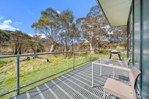 a balcony of a house with a grill and trees at Ecocrackenback 5 in Crackenback