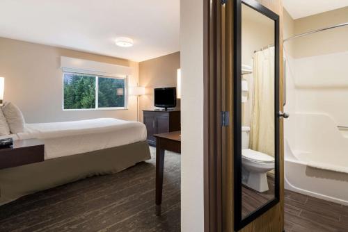 a hotel room with a bed and a bathroom at Best Western Mt. Hood Inn in Government Camp