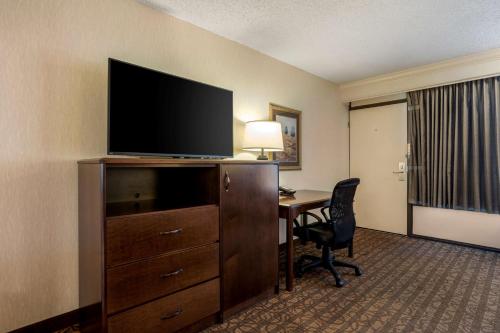 a hotel room with a desk and a flat screen tv at Best Western Inn of the Ozarks in Eureka Springs