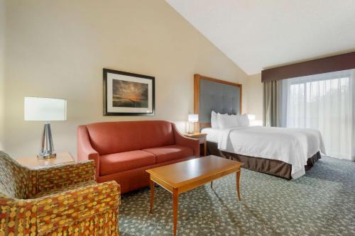 Best Western Plus Oak Harbor Hotel and Conference Center في أوك هاربور: غرفه فندقيه بسرير واريكه