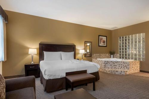 a hotel room with a bed and a bath tub at Best Western Plus Baker Street Inn in Nelson