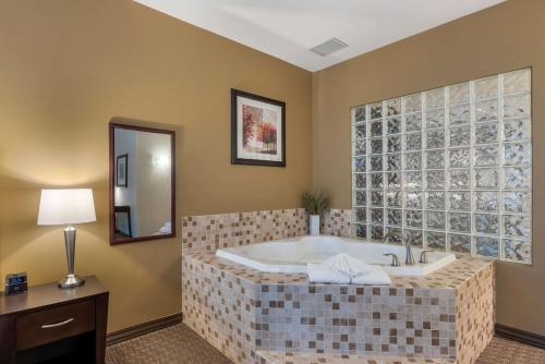 eine große Badewanne in einem Zimmer mit Spiegel in der Unterkunft Best Western Plus Baker Street Inn in Nelson