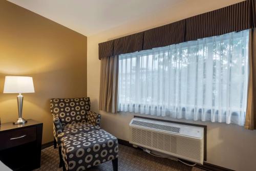 a hotel room with a chair and a window at Best Western Plus Baker Street Inn in Nelson