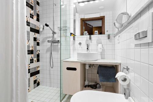 La salle de bains blanche est pourvue d'un lavabo et d'une douche. dans l'établissement Best Western Hotel Akersberga, à Åkersberga