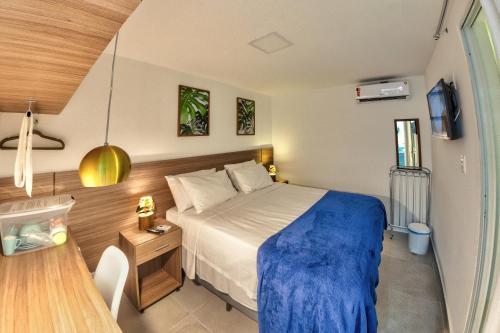 a bedroom with a bed with a blue blanket at Flats Angatu Porto de Galinhas PE in Porto De Galinhas