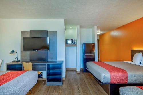 Habitación de hotel con 2 camas y escritorio con TV. en Motel 6-Percival, IA, en Percival