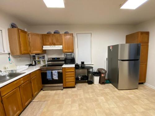 a kitchen with wooden cabinets and a stainless steel refrigerator at A cozy house on a waterfront property in Baltimore