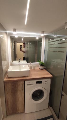 a bathroom with a sink and a washing machine at The PM - in the heart of Thessaloniki in Thessaloniki