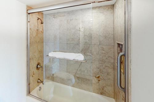 a glass shower door with a sink in a bathroom at Breakers East 604 in Destin