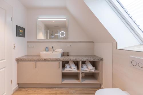 a bathroom with a sink and a mirror at Getidenhus Moand in Sankt Peter-Ording