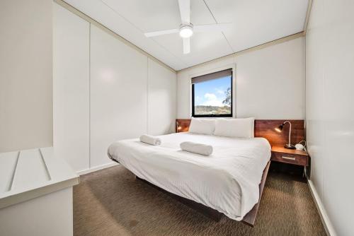 a bedroom with a large bed and a window at Ecocrackenback 9 Sustainable chalet close to the slopes in Crackenback