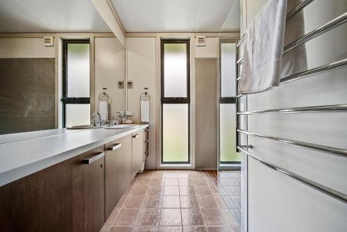 uma cozinha com um frigorífico e piso em azulejo em Ecocrackenback 9 Sustainable chalet close to the slopes em Crackenback