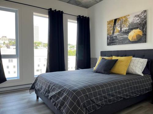 1 dormitorio con 1 cama con almohadas azules y amarillas en Joli condo en basse-ville - Parking gratuit 309357 en Quebec