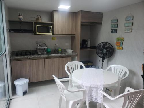 a kitchen with a table and chairs and a microwave at Flats Angatu Porto de Galinhas PE in Porto De Galinhas
