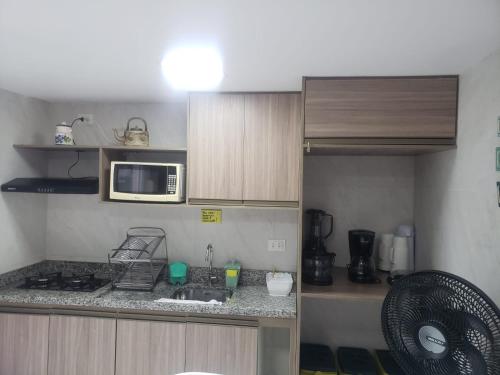 a small kitchen with a sink and a microwave at Flats Angatu Porto de Galinhas PE in Porto De Galinhas