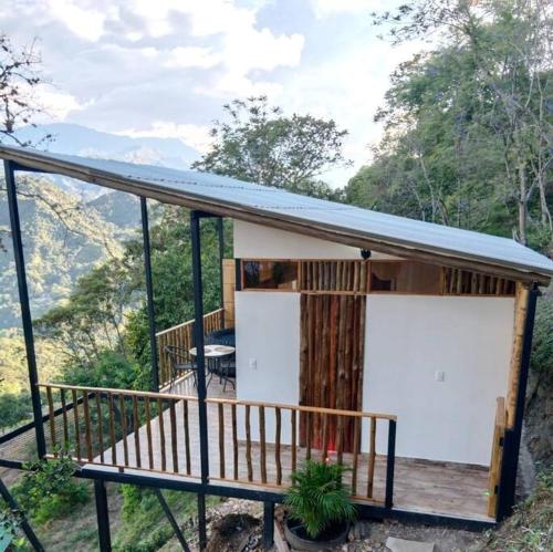 a small house with two white doors on a deck at Glamping Bellavista in La Vega