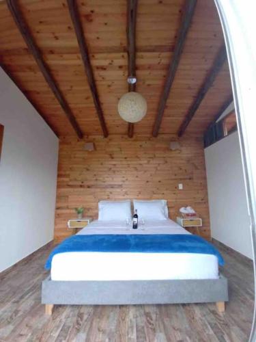 a bedroom with a large bed in a wooden room at Glamping Bellavista in La Vega