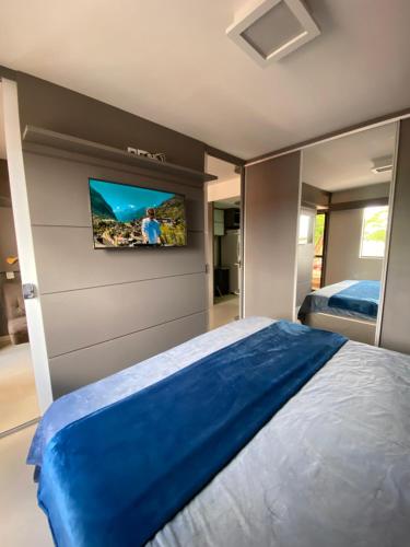 a bedroom with a bed and a tv on the wall at Flat Decoração Náutica c/Vista Lago Paranoá in Brasilia