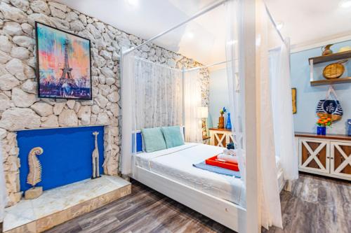 a bedroom with a bed and a stone wall at Palms Cottage at Viking Hill in Nassau