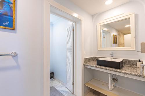 uma casa de banho com um lavatório e um espelho em Palms Cottage at Viking Hill em Nassau