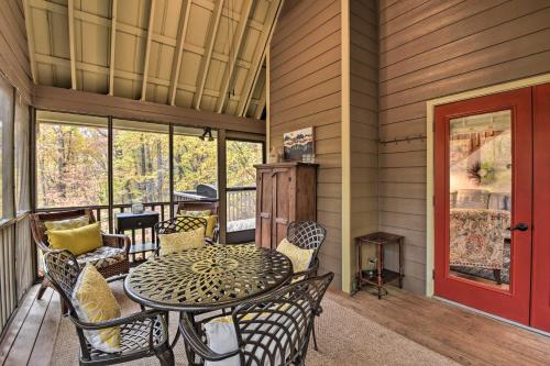 a porch with a table and chairs and a red door at Big Canoe Cabin with Mountain View, Hiking and Lake! in Marblehill