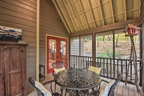 a patio with a table and chairs on a porch at Big Canoe Cabin with Mountain View, Hiking and Lake! in Marblehill
