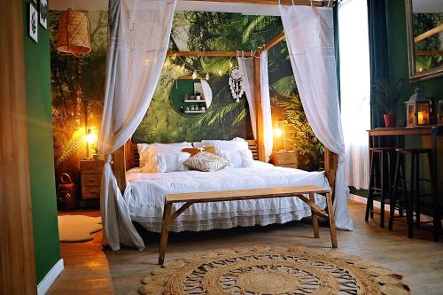 1 dormitorio con 1 cama con dosel en La jungle sauvage insolite spa écran cinéma 5 min centre ville, en Évreux