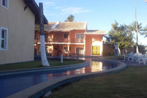 a house with a pool in front of a house at Village em Condomínio c/ piscina e acesso a praia in Camaçari