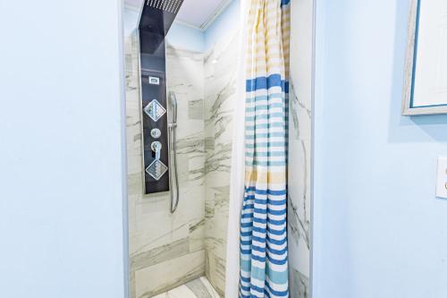 y baño con ducha y cortina de ducha. en Sunset Cottage at Viking Hill, en Nassau