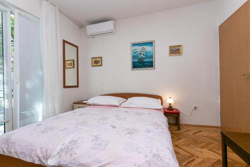 a bedroom with a bed and a window at Apartments by the sea Gradac, Makarska - 20041 in Gradac