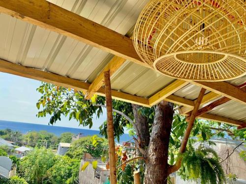 patio z drzewem i słomianym parasolem w obiekcie Casita Lodge Kubo w mieście San Juan