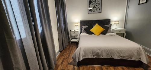 a bedroom with a bed with a yellow pillow at Hotel Voila Londres in Santiago