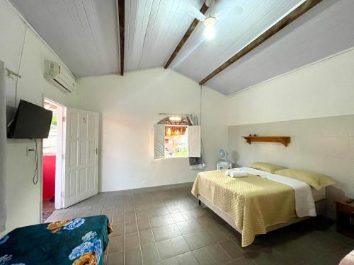a bedroom with a bed and a tv in a room at Pousada Kawaii in Arraial d'Ajuda
