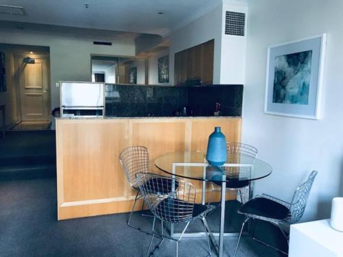 a kitchen with a glass table and chairs at Fantastic location - apartment in Sydney CBD BON02617 in Sydney