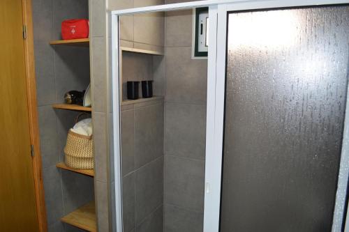 a walk in shower with a glass door in a bathroom at Casa do Arrodeio in São Mateus