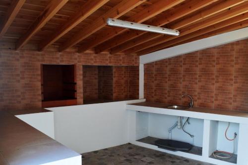 a kitchen with a sink and a brick wall at Casa do Arrodeio in São Mateus