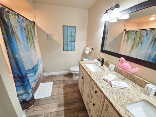 a bathroom with two sinks and a large mirror at Bahamian Cottage - Heated Pool Walk to the Beach in Cocoa Beach