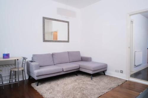 a living room with a couch and a table at The Lodge - Newly Refurbished Suite with Dedicated Office Space in Weybridge