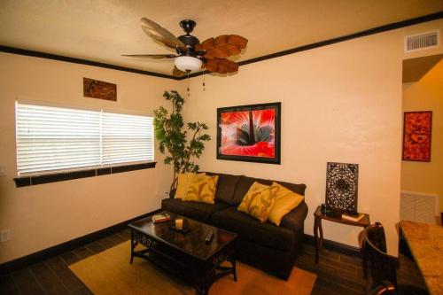 Una sala de estar con un sofá y un ventilador de techo. en Tahitian Cottage - Heated Pool Walk to the Beach, en Cocoa Beach