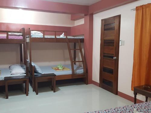 a room with two bunk beds and a door at D'MESA Seacretlodge and Restaurant in Taytay
