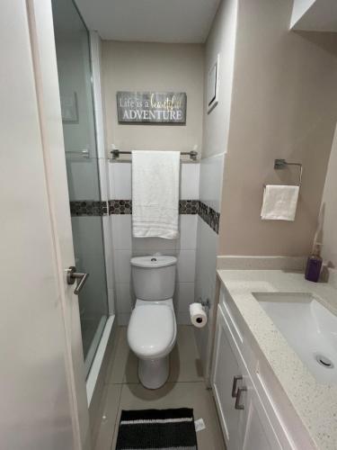 Baño pequeño con aseo y lavamanos en Large Luxurious Beach Front 1 Bedroom at Bayfront Villa en Portmore