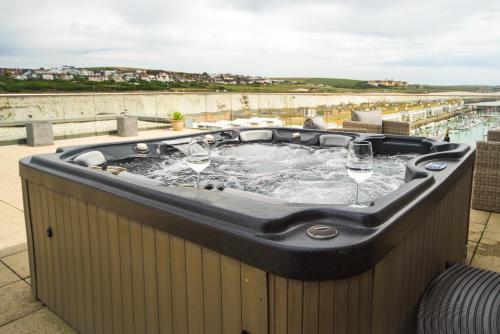 a hot tub with wine glasses in it on a patio at Unique Sea View Penthouse with Hot Tub in Brighton & Hove