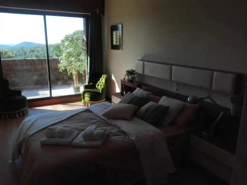 ラス・ナバス・デル・マルケスにあるCasa Rural Mauriのベッドルーム1室(大きなベッド1台、大きな窓付)