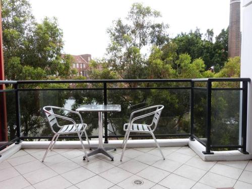 un patio con 2 sillas y una mesa en el balcón en Ultra Convenient Apartment HER09029 en Sídney