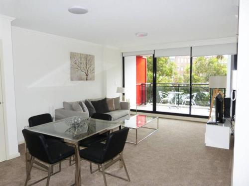 a living room with a table and a couch at Ultra Convenient Apartment HER09029 in Sydney
