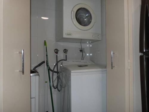 Ultra Convenient Apartment HER09029 في سيدني: حمام مع مغسلة وغسالة ملابس