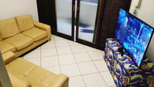 a living room with a couch and a flat screen tv at Hostel da Floresta in Vitória