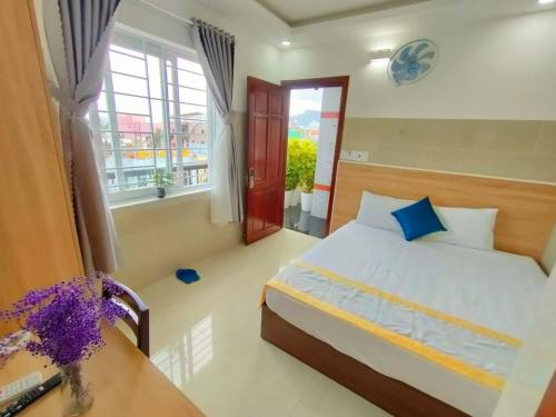 um quarto com uma cama, uma mesa e uma janela em SixPearl Hotel em Con Dao