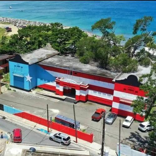 a red white and blue building next to the ocean at Summer all year! Oceanfront with Pool A/C in Aguadilla