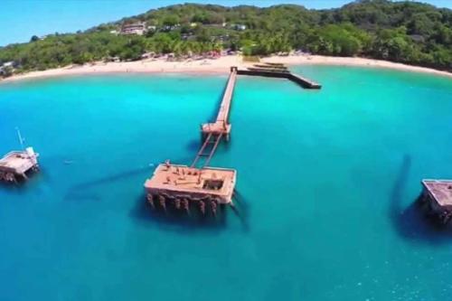 a boat floating in the water next to a beach at Summer all year! Oceanfront with Pool A/C in Aguadilla
